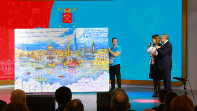Александр Беглов передал директору выставки «Россия» Наталье Виртуозовой панораму современного Петербурга, созданную художниками и гостями стенда города